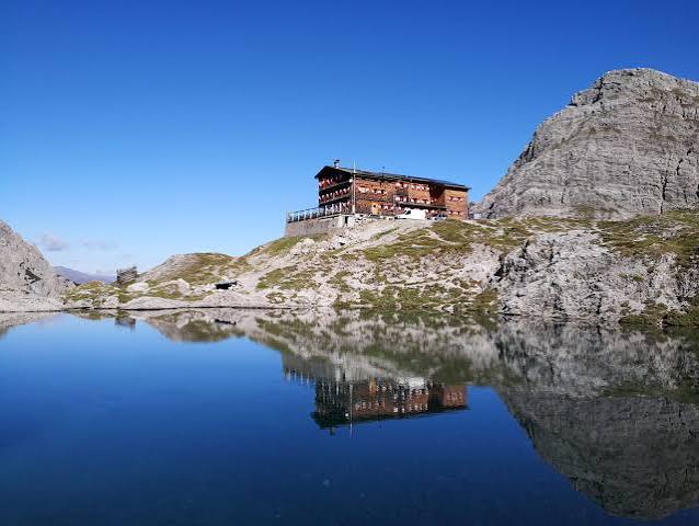 Die Kalsbader Hütte spiegelt sich in einem Bergsee